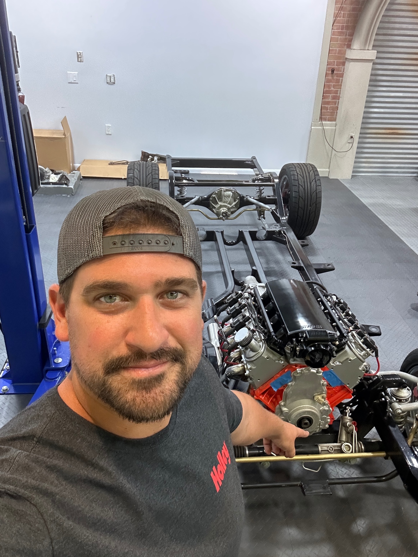 Joe, owner of Mission Ready Motor Company, pointing out the chassis of a car he is repairing
